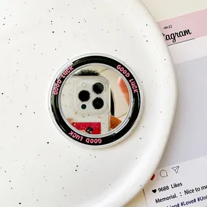Detail eines runden magnetischen Handy-Spiegels mit rosa Good Luck Text auf Keramik