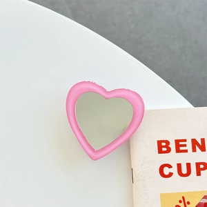 Close-up of pink heart-shaped folding phone socket with high-reflection makeup mirror