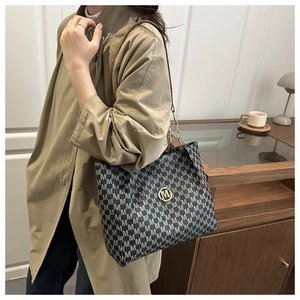Détail du sac cabas gris monogrammé avec logo M doré et bandoulière en chaîne