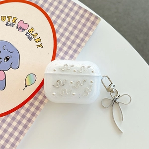 Detail of glitter AirPods Pro case with silver snake motif and bow pendant keychain