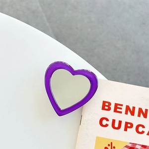 Detail shot of heart-shaped purple phone grip with mirror finish on magazine background