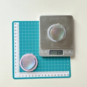 Detail view of 33.5g strawberry resin phone grip showing 50mm diameter on scale