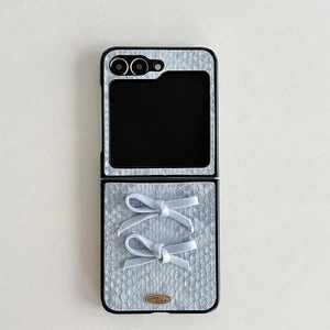 Detail of grey crocodile texture case with fabric bows and gold Love is forever tag