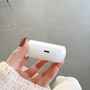 Dettagli dei ritagli di ricarica precisi e borchie dorate sulla custodia bianca per AirPods