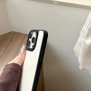 Detail shot of iPhone leather case with white wrinkled texture and black matte edges