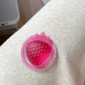 Close-up of a 3D translucent red strawberry phone grip on white knitted fabric