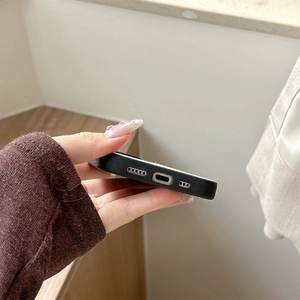 Detail showing precise charging port and speaker cutouts on the black matte phone case
