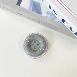 Detailed top view of a minimalist marble-pattern button phone socket on a white surface