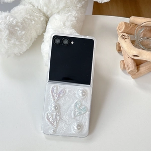 Detailed view of Samsung Z Flip case featuring iridescent hearts and pearl decorations