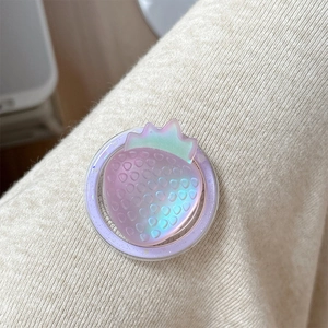 Macro shot of 3D holographic strawberry phone grip with glittery purple base on fabric