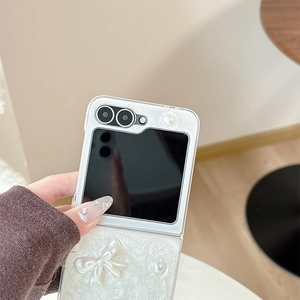 Detail of white Galaxy Z Flip case with cloud texture, large 3D bow, and pearl accents