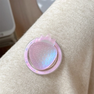 Detailed view of pink iridescent strawberry phone grip on soft knitted background