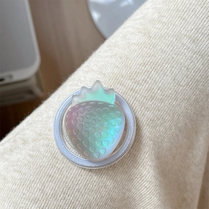 Macro view of a 3D translucent strawberry phone grip with iridescent finish on knit fabric