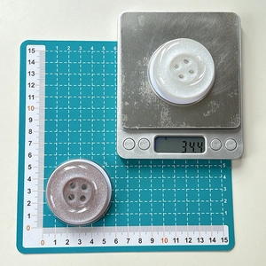 Macro detail of the button phone socket showing 40mm diameter on a blue scale mat
