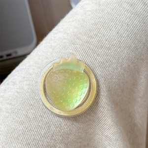 Close-up of a shimmering green strawberry magnetic phone stand with glitter details