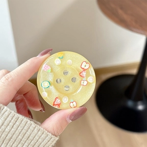 Detail of yellow glitter resin phone grip with miniature fruit slice decorations