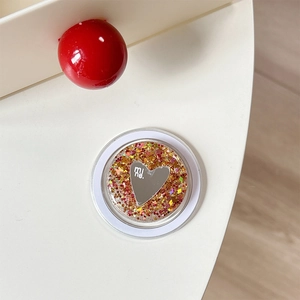 Macro shot of circular phone stand featuring a glitter heart mirror with mine engraving