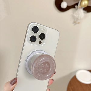 Macro detail of lavender glitter button phone grip stand on a white smartphone