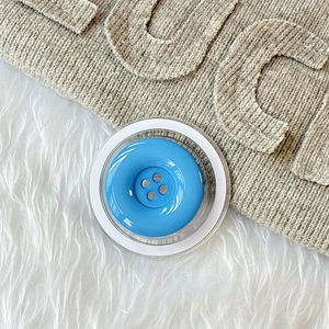 Detailansicht eines hellblauen magnetischen Handyhalters im Knopfdesign mit Klarsichtrahmen