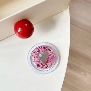 Close-up of heart mirror phone grip with pink and blue glitter sequins and brand logo