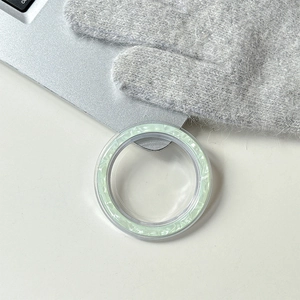 Dettaglio del supporto magnetico per telefono con texture in pietra verde chiaro su tavolo