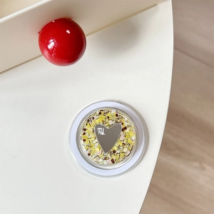 Close-up of yellow glitter griptok with heart mirror and mine engraving on desk