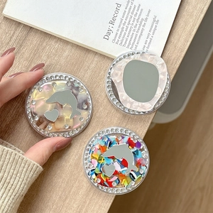 Rhinestone magnetic phone grip with mirror dolphin and heart motifs on wooden desk
