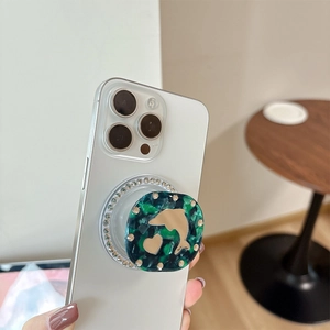 Close-up of rhinestone magnetic phone socket with marble pattern and golden dolphin charm