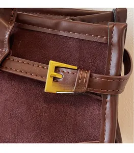 Detail of vintage baguette bag featuring brown leather, suede texture, and gold buckle