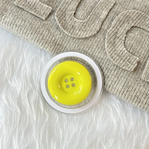 Makroaufnahme der magnetischen gelben Handyhalterung mit Lucky-Stickerei und Button-Design