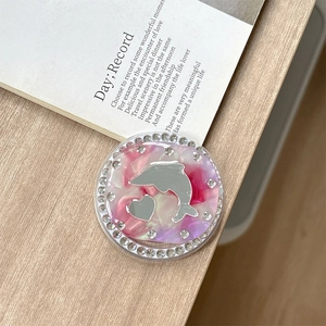 Detail of a pink marble resin phone socket with dolphin mirror and rhinestone edges