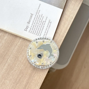 Macro view of shell texture magnetic phone grip with rhinestones and dolphin icon