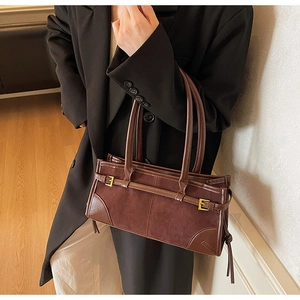 Detail of dark brown vintage tote featuring suede and smooth leather patchwork
