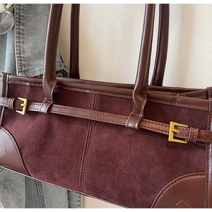 Close-up of dark brown vintage tote bag showing suede texture and golden buckle detail