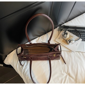 Macro view of retro dark brown tote bag showing striped lining and interior zip pocket