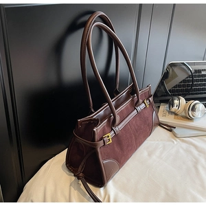 Close-up of retro brown suede tote bag with leather straps and gold metal hardware