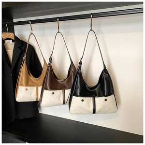 Chic tote bags in khaki, brown, and black with faux fur patchwork hanging on a rack