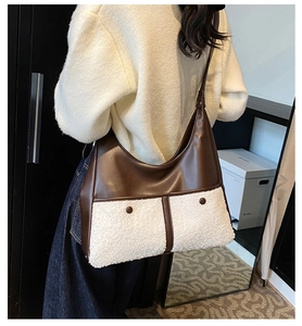 Detail of hobo bag in brown leather and white faux shearling with dual front snap pockets