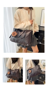 Detail of dark brown PU leather tote bag with ethnic style strap and plush charm