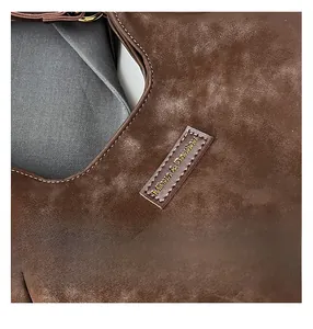 Macro shot of dark brown frosted leather texture and precise logo stitching details
