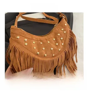 Dettaglio borsa hobo in pelle scamosciata marrone con borchie e lunghe frange