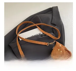 Dettaglio borsa a tracolla in pelle scamosciata marrone con frange e borchie dorate