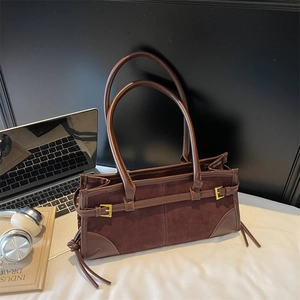 Brown faux leather tote bag with minimalist gold buckles for 2025 fashion trend