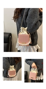 Sac seau tissé rose avec poignée en perles et bandoulière en chaîne dorée