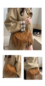 Dettaglio della borsa in pelle scamosciata marrone con borchie dorate e lunghe frange
