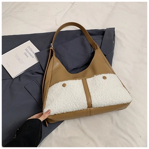 Detail of vintage brown leather and white faux fur patchwork tote with buckle pockets