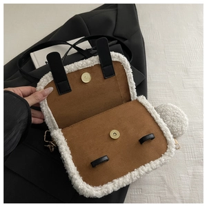 Detail of white plush crossbody bag showing brown suede lining and magnetic gold clasp