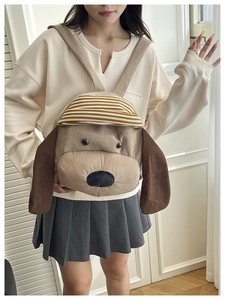 Detail of cute brown corduroy puppy backpack with long ears and striped hat
