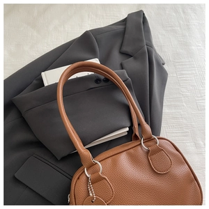 Détail du sac à main en cuir litchi marron caramel avec anneaux en métal argenté