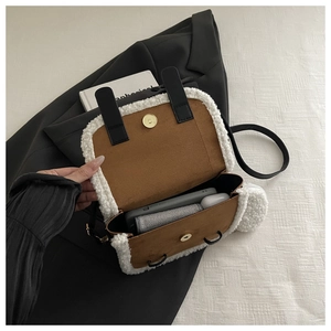 Interior view of suede and faux fur handbag showing storage for phone and accessories